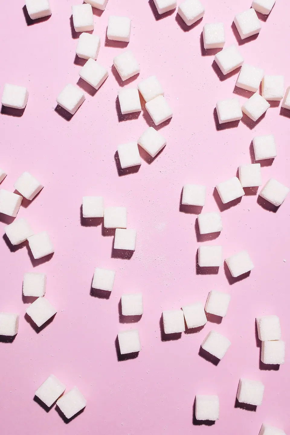 Cubos de azúcar sobre fondo rosa