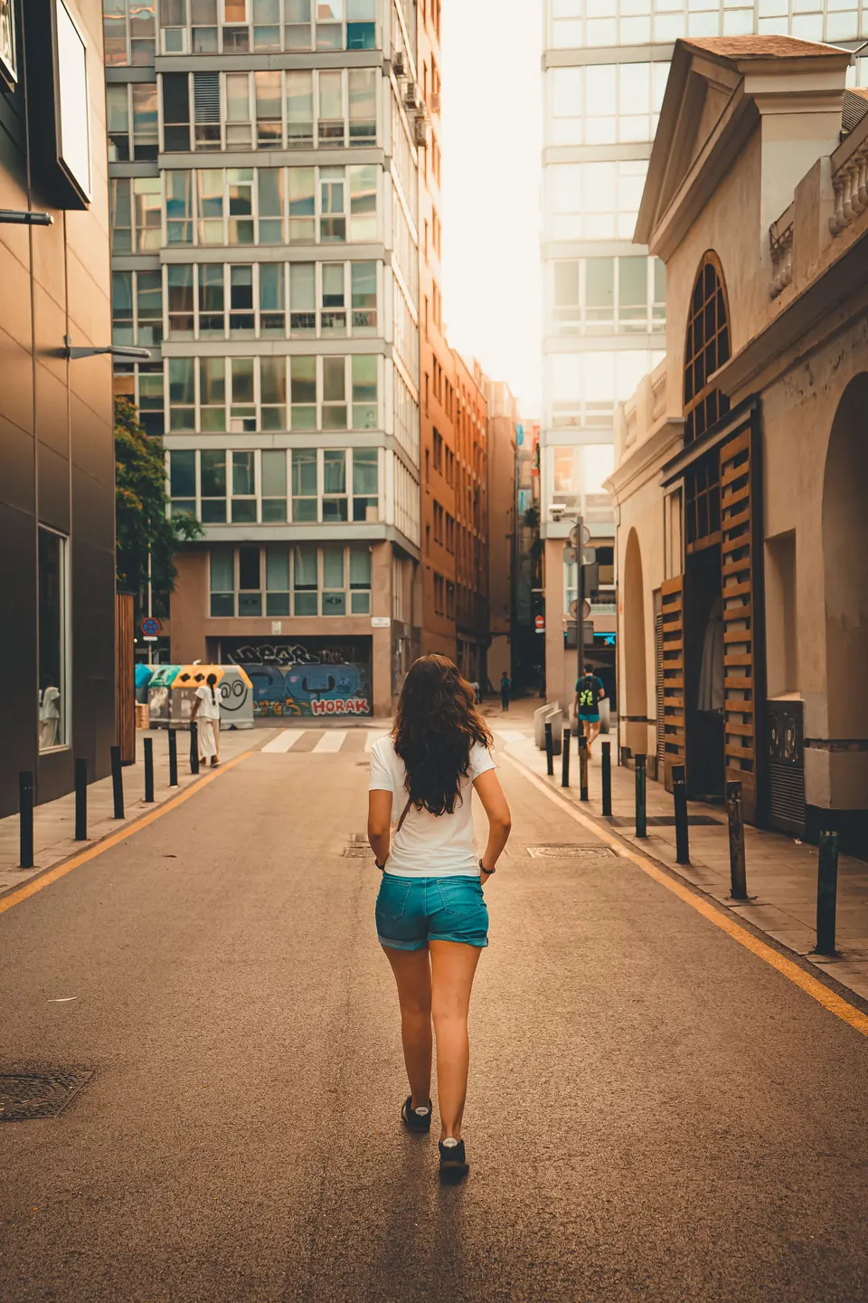 Mujer caminando por una calle soleada
