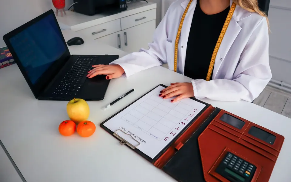 Nutrióloga trabajando en un plan de alimentación en su laptop